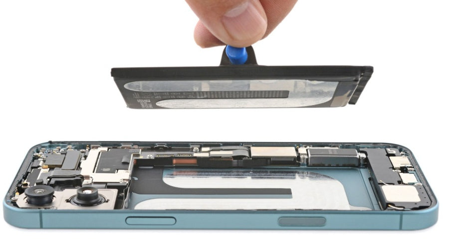Hand removing battery from disassembled smartphone using repair tool, mobile phone parts visible