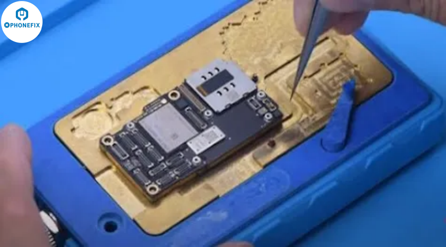 Hands repairing smartphone motherboard with tweezers on a blue anti-static mat