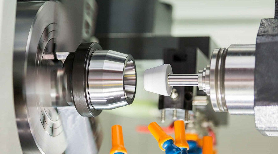 CNC lathe grinding a metal automotive part in a precision machining workshop