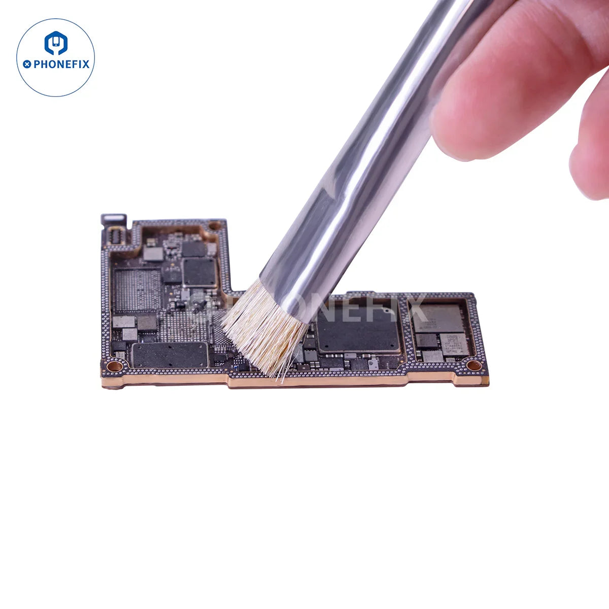 Hand using a cleaning brush on a mobile phone motherboard for repair