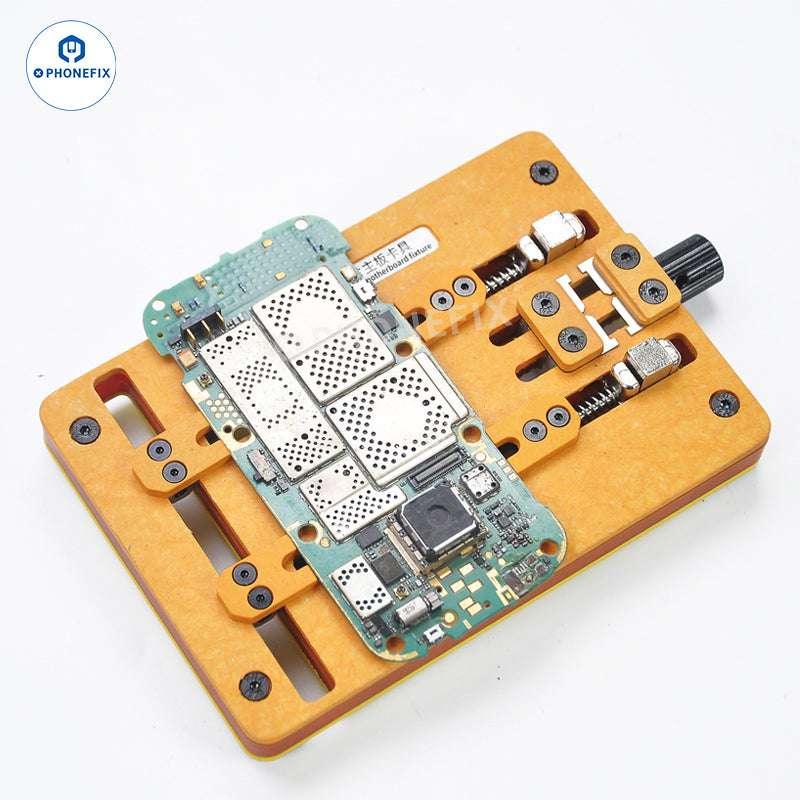 PhoneFIX heat-resistant soldering clamp holding an iPhone motherboard for testing and repair procedures.