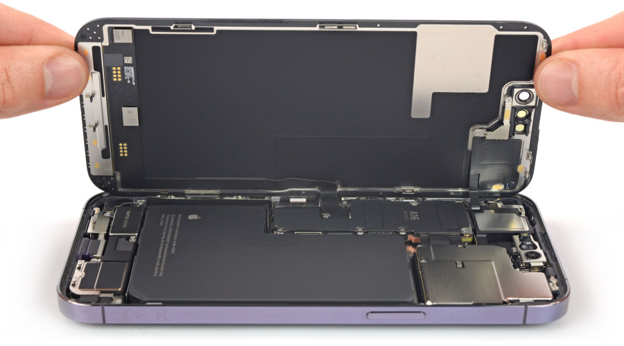 Hands opening a smartphone to show internal components and battery for repair
