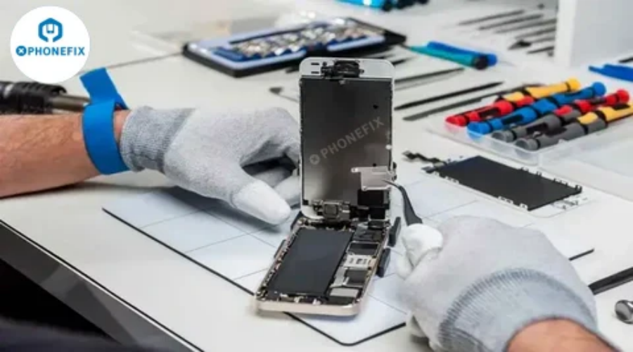 Technician repairing smartphone using phone repair tools kit on workbench